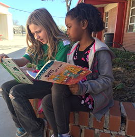 Two students reading books outside