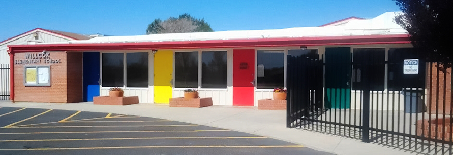 Exterior view of school building with various colored classroom doors